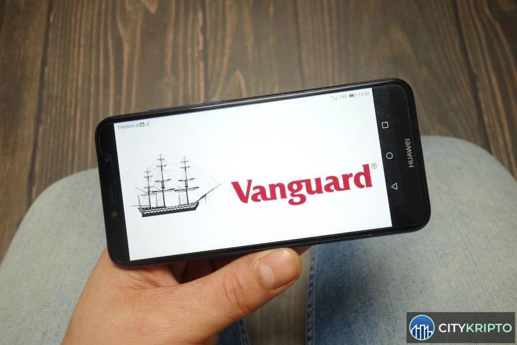 Логотип Vanguard на фоне графиков криптовалют