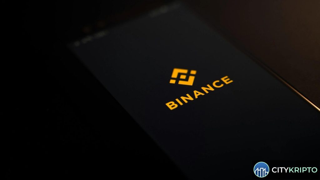 Логотип Binance на фоне графиков криптовалют