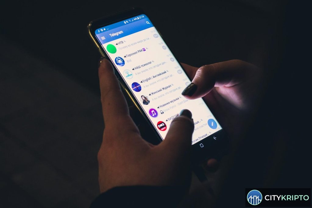 Павел Дуров на фоне логотипа Telegram и биткоина
