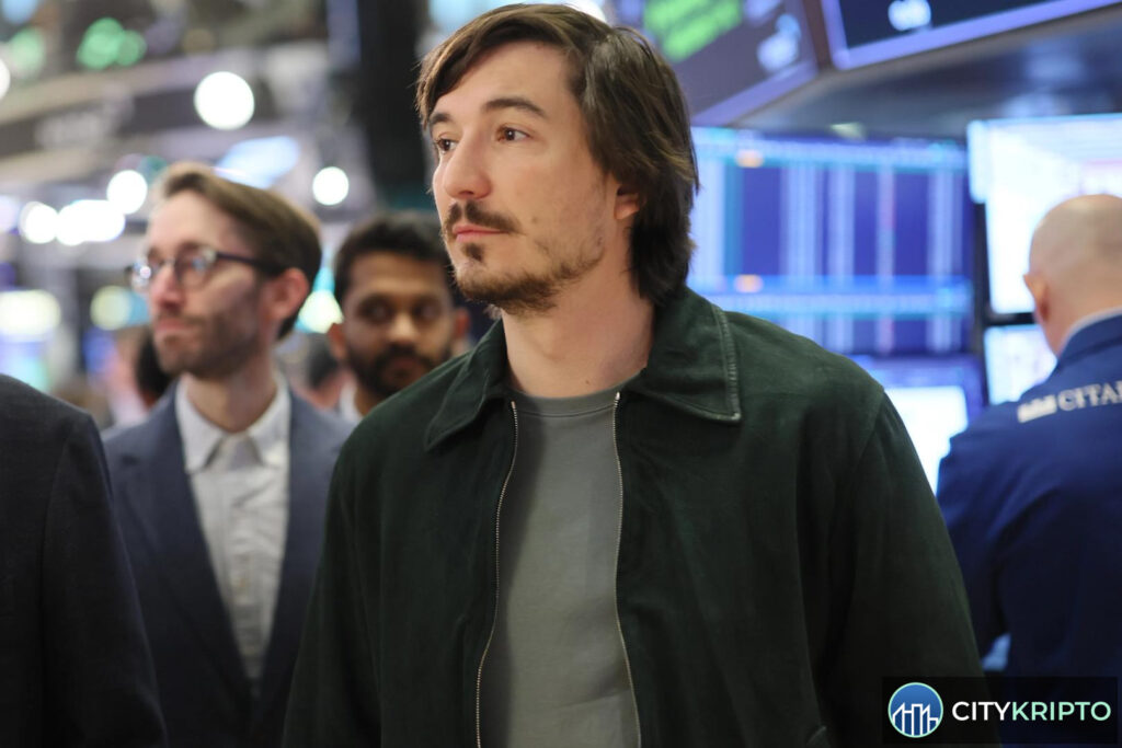 Влад Тенев, генеральный директор Robinhood, на фоне логотипов AMC и блокчейн-токенов
