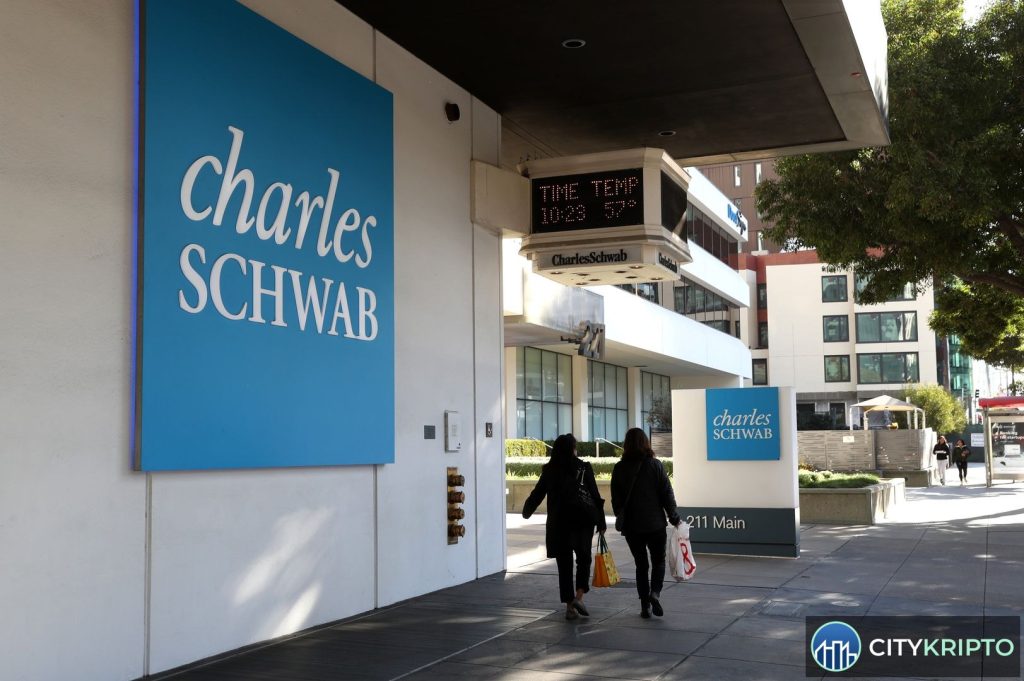 Логотип Schwab с символами Bitcoin и Ether на фоне графика криптовалютного рынка